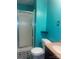 Bathroom featuring an aqua-colored wall, corner shelves, enclosed shower, and geometric tiled floor pattern at 734 Harris Nw St, Concord, NC 28025