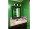 Unique bathroom featuring vibrant green walls, a black framed mirror, and modern black and gray tiled backsplash at 734 Harris Nw St, Concord, NC 28025