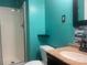 Bathroom featuring an aqua-colored wall, corner shelves, enclosed glass shower, and black & white tiled backsplash at 734 Harris Nw St, Concord, NC 28025