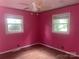 Bright bedroom with two windows, wood floors, ceiling fan and charming pink walls at 734 Harris Nw St, Concord, NC 28025
