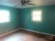 Well-lit bedroom featuring light blue walls, hardwood floors, two windows, and simple electrical outlets at 734 Harris Nw St, Concord, NC 28025