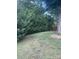 Lush side yard featuring tall, mature evergreen trees and a fenced area at 734 Harris Nw St, Concord, NC 28025