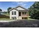 Charming single-story home featuring light beige siding, a cozy front porch, and a newly paved driveway at 809 Fisher St, Kannapolis, NC 28027
