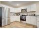 Bright kitchen featuring white cabinetry, granite countertops, and stainless steel appliances with modern fixtures at 809 Fisher St, Kannapolis, NC 28027