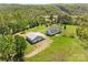 Aerial view of a home and a large garage with lush greenery and a serene, wooded backdrop at 1046 Linneys Mill Rd, Union Grove, NC 28689