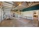 Large open garage area with overhead lighting, shelving, concrete floor, and an attached room at 1046 Linneys Mill Rd, Union Grove, NC 28689