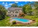 A spacious backyard features a gunite pool, wooden deck, lush green landscaping and a multi-story home at 110 Preserve Way, Mooresville, NC 28117