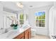 Bright bathroom features double sinks, cherry cabinets, and large windows with natural light at 110 Preserve Way, Mooresville, NC 28117