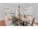 Elegant dining room with hardwood floors, a decorative chandelier, and an open view into the foyer and living areas at 110 Preserve Way, Mooresville, NC 28117