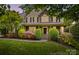 Charming home featuring stone accents, manicured landscaping, a covered porch, and elegant architectural details at 110 Preserve Way, Mooresville, NC 28117