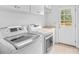 Bright laundry room featuring a washer, dryer, white cabinets, and exterior door at 110 Preserve Way, Mooresville, NC 28117