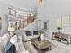 Bright living room features a soaring ceiling, wooden staircase, and neutral-toned decor at 110 Preserve Way, Mooresville, NC 28117