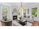 Cozy living room with a fireplace, large windows, and comfortable seating, creating a relaxing atmosphere at 110 Preserve Way, Mooresville, NC 28117