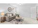 Living room with a cozy sofa, ottoman, stylish decor, and natural light at 110 Preserve Way, Mooresville, NC 28117