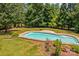 Inviting pool with a stone trim surrounded by a lush lawn and mature trees at 110 Preserve Way, Mooresville, NC 28117