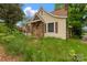 Side view of a cozy home featuring stone accents and a chimney, surrounded by lush greenery at 114 S 5Th St, Albemarle, NC 28001