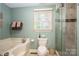 This bathroom features a bathtub, shower, and a window that allows light to enter the room at 118 Sir Gregory Dr, Shelby, NC 28152