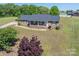 An aerial view of a brick home with a well-manicured front yard, a long driveway, and a landscaped garden at 118 Sir Gregory Dr, Shelby, NC 28152