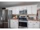 Well-lit kitchen boasts stainless steel appliances, white cabinets, and ample countertop space at 118 Sir Gregory Dr, Shelby, NC 28152
