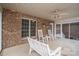 Spacious covered patio with brick walls, ceiling fan, and white rocking chairs at 118 Sir Gregory Dr, Shelby, NC 28152