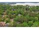 Overhead view of a house surrounded by vibrant, green trees with a serene lake in the background at 121 Northampton Dr, Mooresville, NC 28117