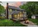 Rear exterior view featuring a screened porch, fire pit and wooded lot at 121 Northampton Dr, Mooresville, NC 28117