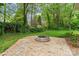 Backyard with a stone fire pit surrounded by lush greenery, ideal for outdoor gatherings and relaxation at 121 Northampton Dr, Mooresville, NC 28117