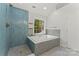 Bright bathroom boasting a modern tub and shower with beautiful tile work and a large window at 121 Northampton Dr, Mooresville, NC 28117