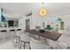 Open dining room with modern lighting, adjacent to an updated kitchen at 121 Northampton Dr, Mooresville, NC 28117