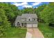 Aerial view of the front exterior, showcasing mature trees, well-maintained lawn and charming curb appeal at 121 Northampton Dr, Mooresville, NC 28117