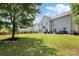 Large backyard features a well-maintained lawn, patio area, and mature tree providing ample shade at 1210 Langdon Terrace Dr, Indian Trail, NC 28079