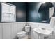 Stylish half bathroom with dark blue walls, white wainscoting, and modern fixtures at 1210 Langdon Terrace Dr, Indian Trail, NC 28079