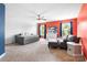 Bright bedroom with orange wall, neutral carpet, windows, ceiling fan, bed, loveseat, and decor at 1210 Langdon Terrace Dr, Indian Trail, NC 28079