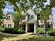 Charming brick home boasts manicured landscaping, a welcoming front porch, and mature trees at 1210 Langdon Terrace Dr, Indian Trail, NC 28079