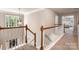 Upstairs hallway with carpet, wood railing, and a view of a bright bedroom at 1210 Langdon Terrace Dr, Indian Trail, NC 28079