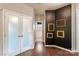 Hallway with wood floors and a decorative black accent wall with gold frames at 1210 Langdon Terrace Dr, Indian Trail, NC 28079