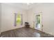 A bare bedroom with wood-look flooring, a window with curtain and an exterior door to the backyard at 1221 Patterson St, Shelby, NC 28152