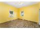 Bright bedroom with yellow walls, two windows, and wood-look floors, ready for personalization at 1221 Patterson St, Shelby, NC 28152