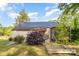 Home exterior with metal roof, landscaping, and a screened-in porch at 1221 Patterson St, Shelby, NC 28152