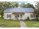 Quaint one-story home featuring a metal roof, small front porch, and lawn at 1221 Patterson St, Shelby, NC 28152