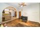 Bright living room with hardwood floors, decorative fan, and archway to the updated kitchen at 1221 Patterson St, Shelby, NC 28152