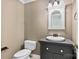 Charming half bath with a classic vanity, decorative mirror and neutral color palette at 16565 Kimbolten Dr, Huntersville, NC 28078