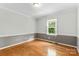 Bright bedroom featuring hardwood floors and a large window, offering ample natural light at 16565 Kimbolten Dr, Huntersville, NC 28078