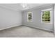 Bright bedroom with plush carpet and two large windows, offering a serene atmosphere at 16565 Kimbolten Dr, Huntersville, NC 28078