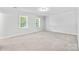 Spacious, bright bedroom with plush carpet and two large windows, offering a serene atmosphere at 16565 Kimbolten Dr, Huntersville, NC 28078