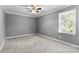 Cozy bedroom with plush carpet and ceiling fan, perfect for relaxation at 16565 Kimbolten Dr, Huntersville, NC 28078