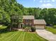 Traditional brick home featuring an attached garage, well-manicured lawn, and mature trees at 16565 Kimbolten Dr, Huntersville, NC 28078