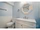 Bathroom features a white vanity, modern mirror, and a tile accent wall at 202 Water Oak Dr, Pineville, NC 28134