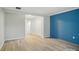 Bright bedroom with wood-look flooring, closet, and a distinctive blue accent wall at 202 Water Oak Dr, Pineville, NC 28134