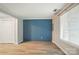 Bright bedroom with wood-look flooring, closet, and a distinctive blue accent wall at 202 Water Oak Dr, Pineville, NC 28134